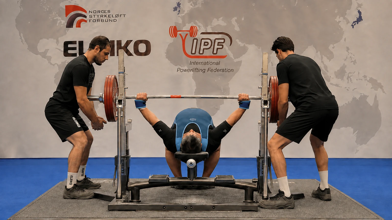 Askar Shokhanov completing a 340-kilogram equipped bench press with two side spotters.