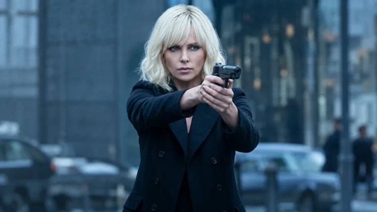Charlize Theron as Lorraine Broughton in Atomic Blonde holding a film prop pistol in a city scene