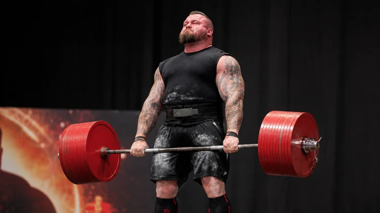 Editorial recreation of Eddie Hall locking out a 500 kg strongman deadlift on an arena stage.