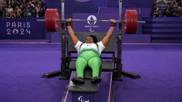 Folashade Oluwafemiayo bench pressing on the Paris 2024 para powerlifting platform.