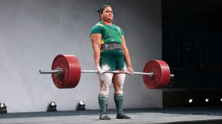 Editorial recreation of Natalie Laalaai locking out a record raw deadlift on an international competition platform.