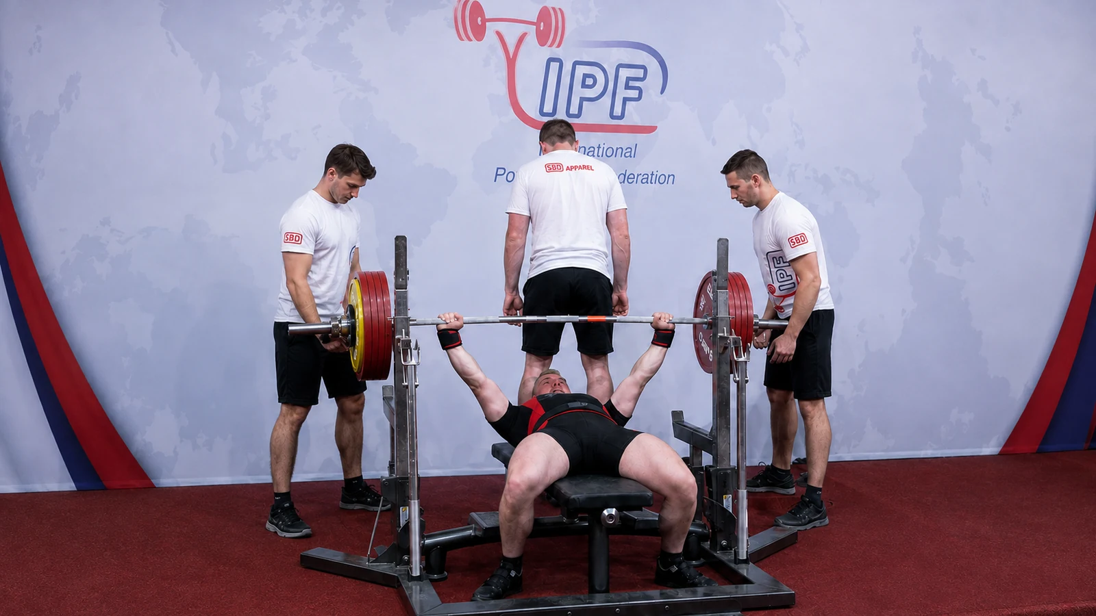 Owen Hubbard completing an IPF raw bench-press attempt with three spotters.
