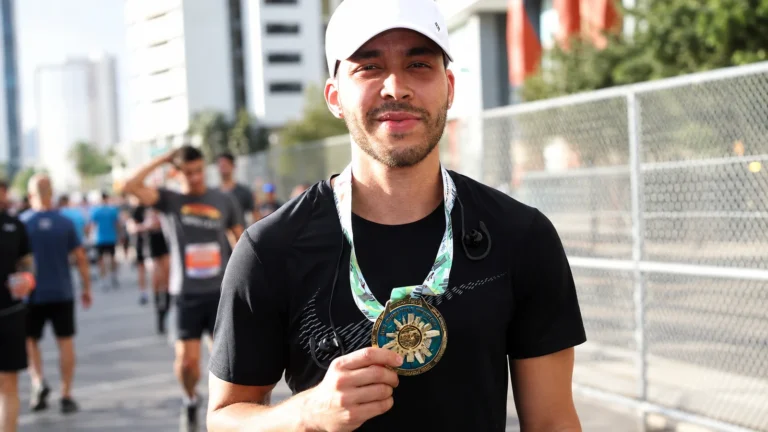 Prince Royce wearing his New York City Marathon finisher medal