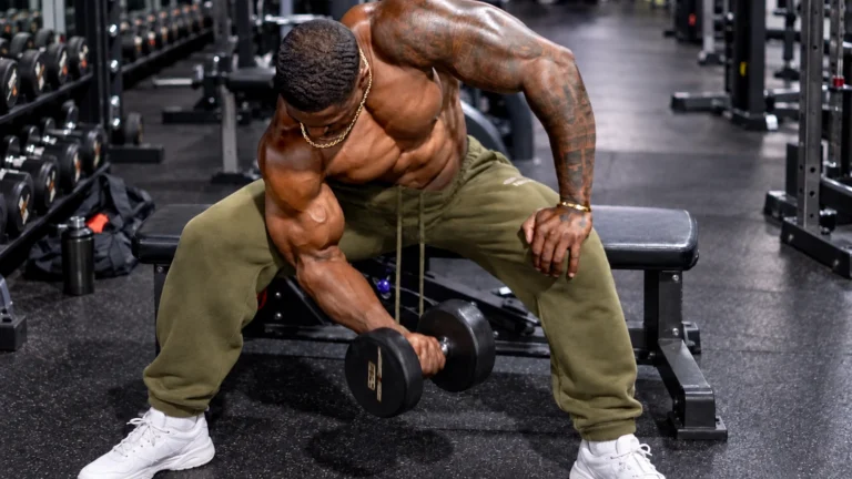 Simeon Panda performs a seated concentration curl in a gym