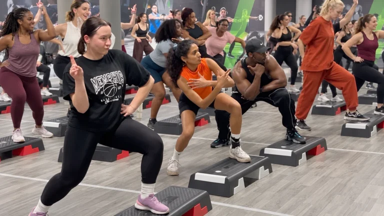 Diverse group doing step aerobics on stable platforms in a gym, matched to the source Facebook creative without overlay text